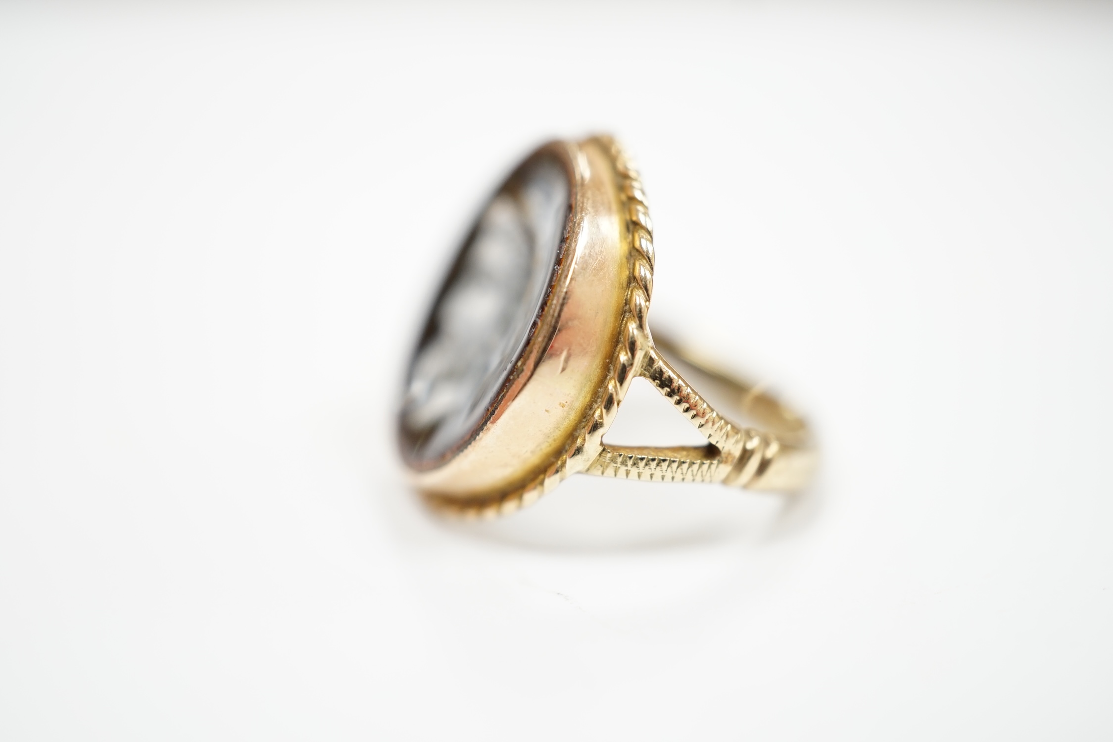 An antique 9ct and enamel set circular ring, depicting the head of a gentleman to dexter, size G, gross weight 3.2 grams.
